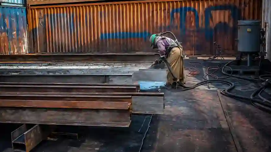 Blaster performing abrasive blasting on steel structures during surface preparation